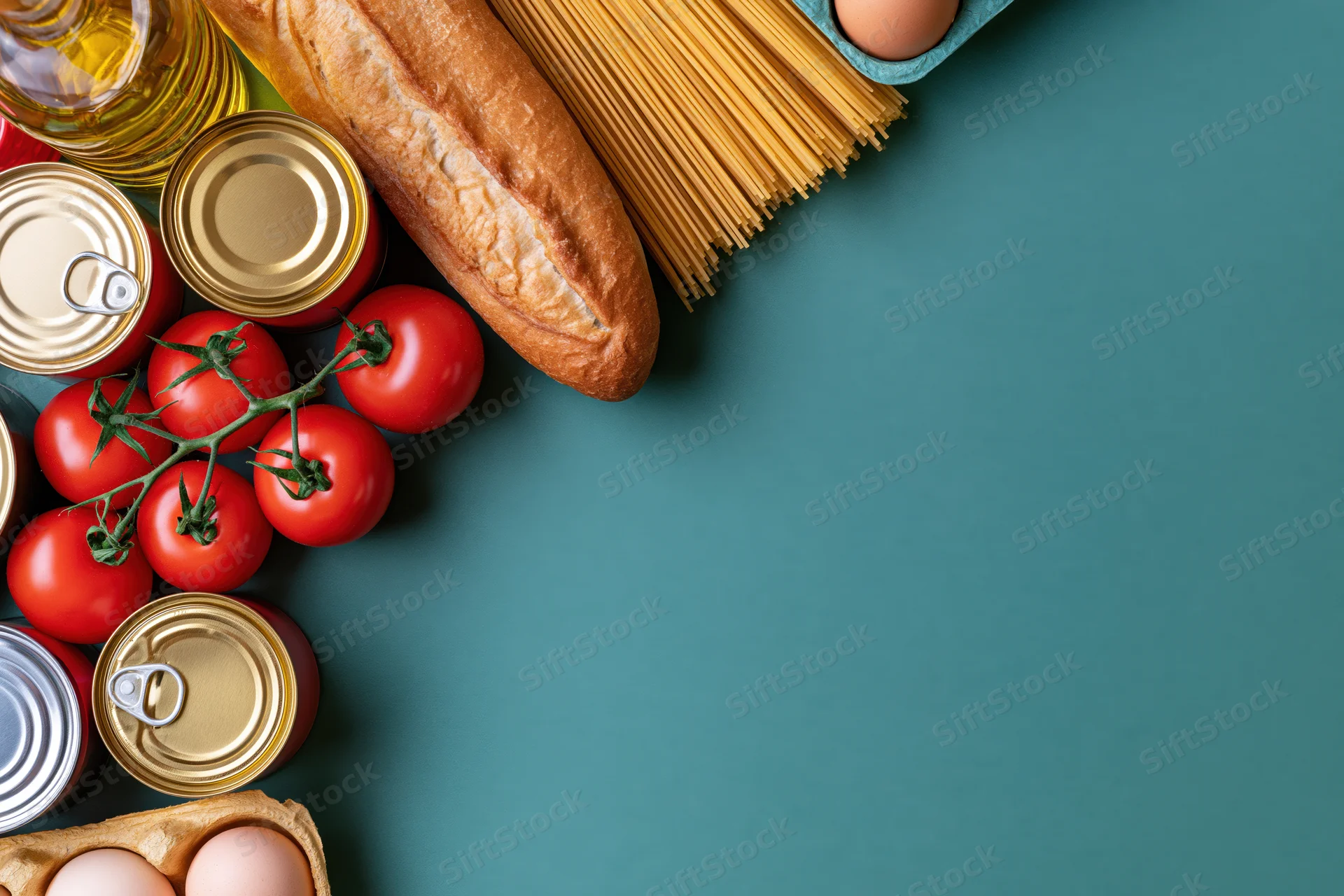 Pantry staples arranged along left edge of teal surface with copyspace on right