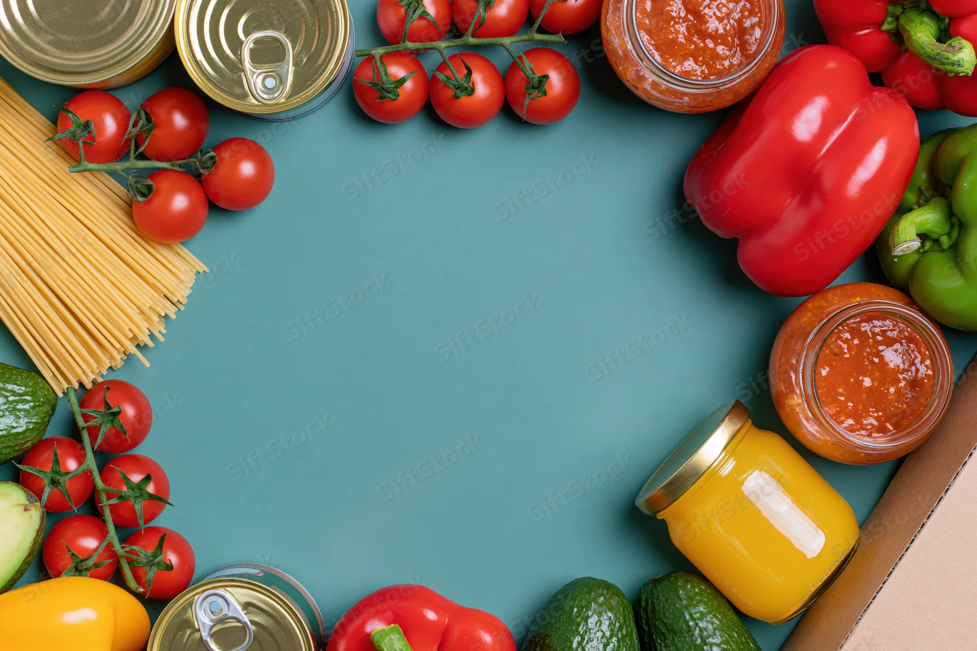 Assorted groceries arranged in a frame around a blue surface with copyspace in center