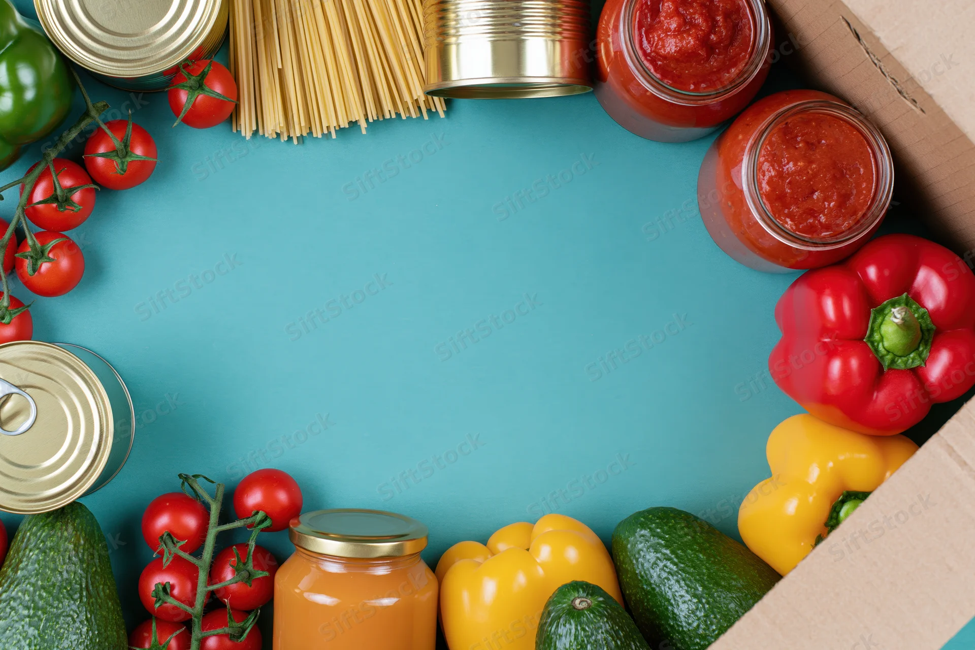 Assorted groceries arranged in a border around a blue surface with copyspace in center