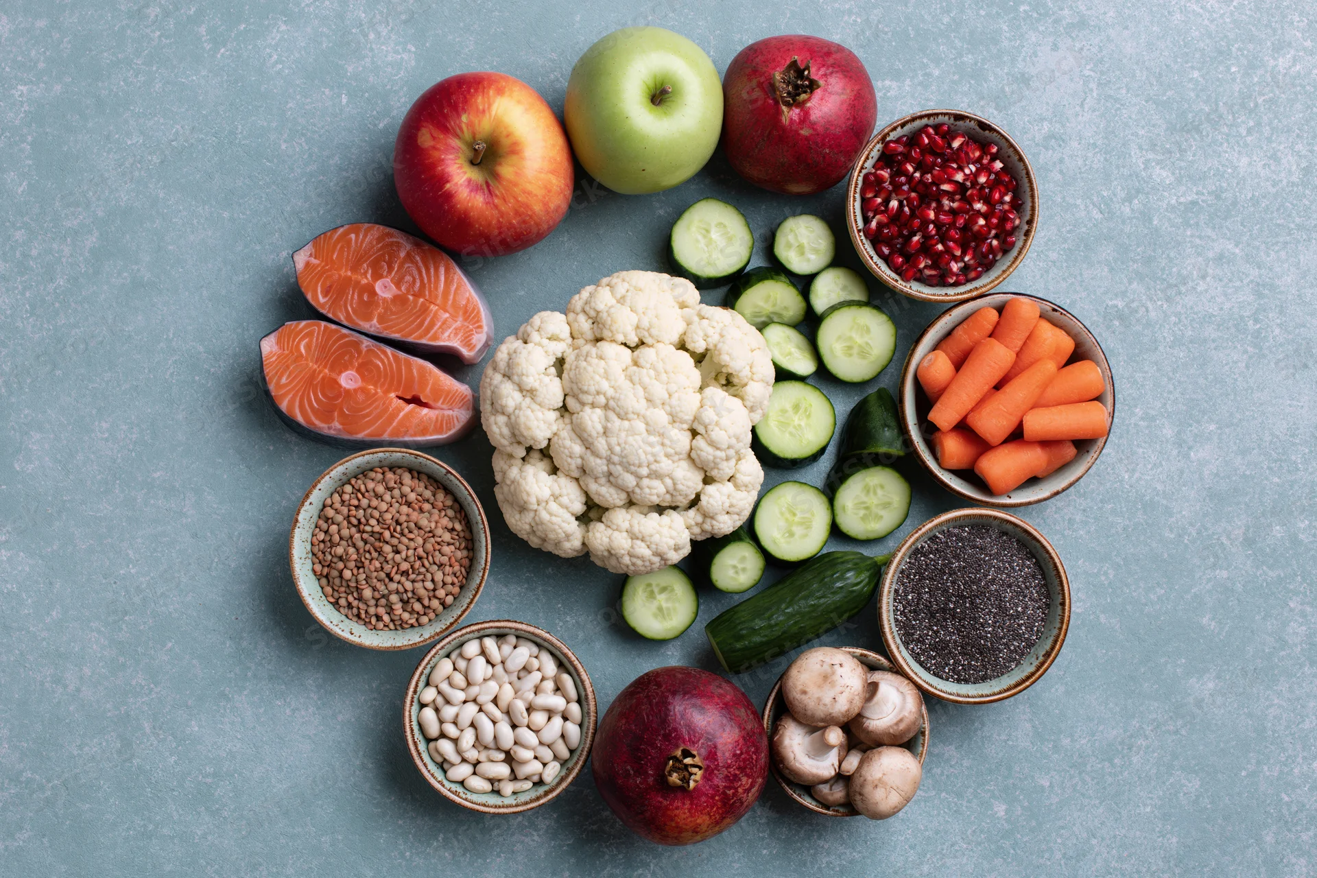 Assorted whole foods arranged in a circular pattern on a stone surface