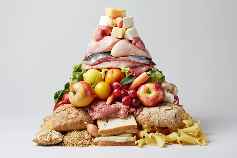 Food pyramid made of real ingredients arranged in layers on white background
