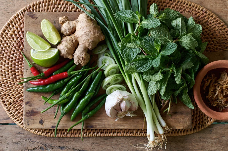 Fresh vietnamese pho ingredients arranged on a wooden cutting board with herbs and spices