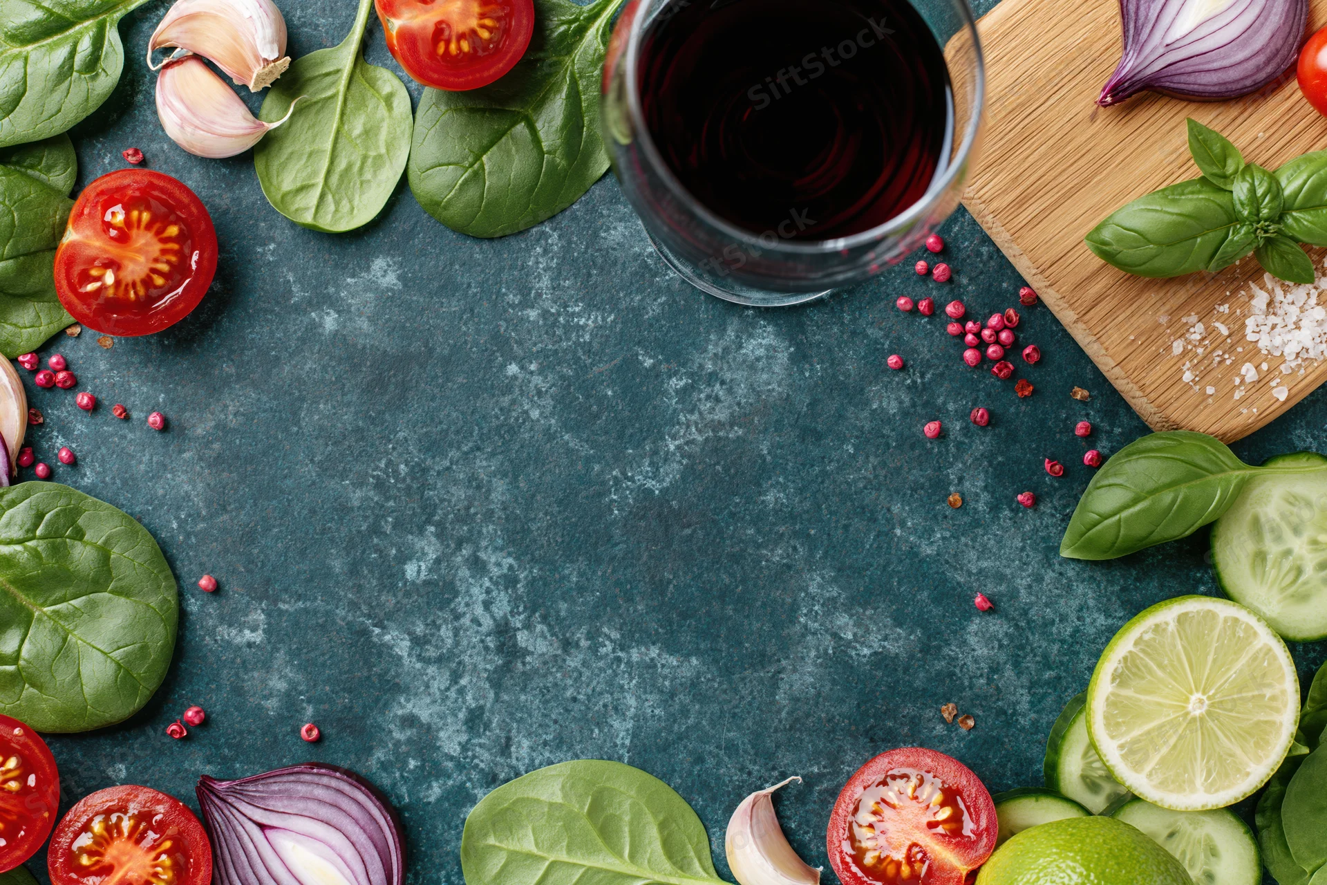 Salad ingredients arranged around edges of dark countertop with copyspace in center
