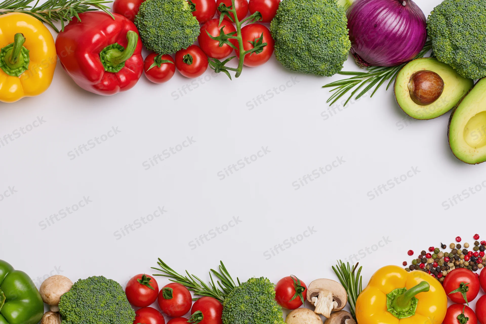 Fresh vegetables and herbs arranged in two horizontal borders on white surface with copyspace