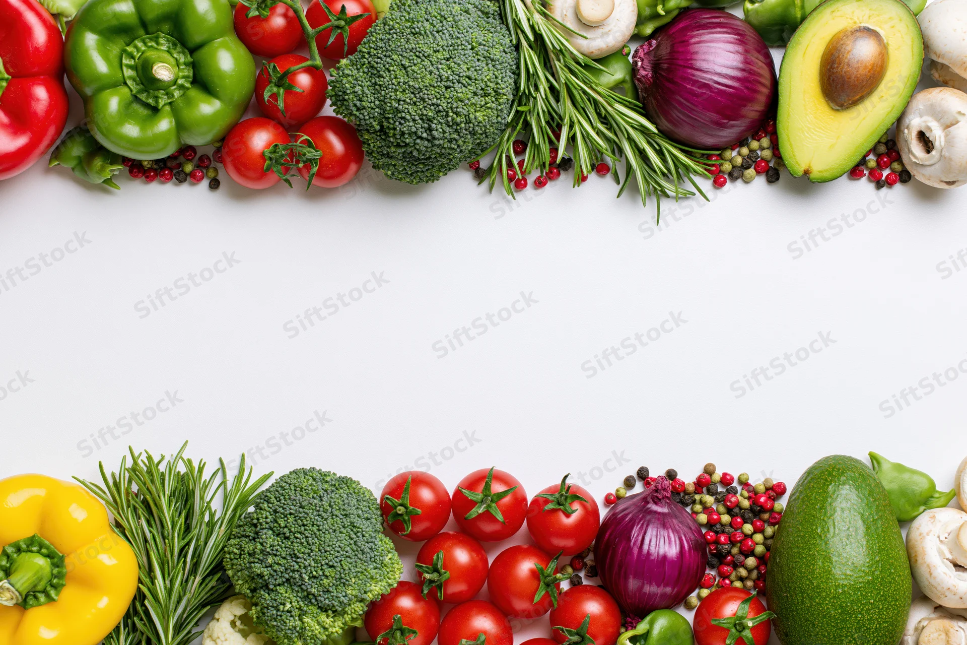 Fresh vegetables and herbs arranged in two horizontal borders on white background with copyspace