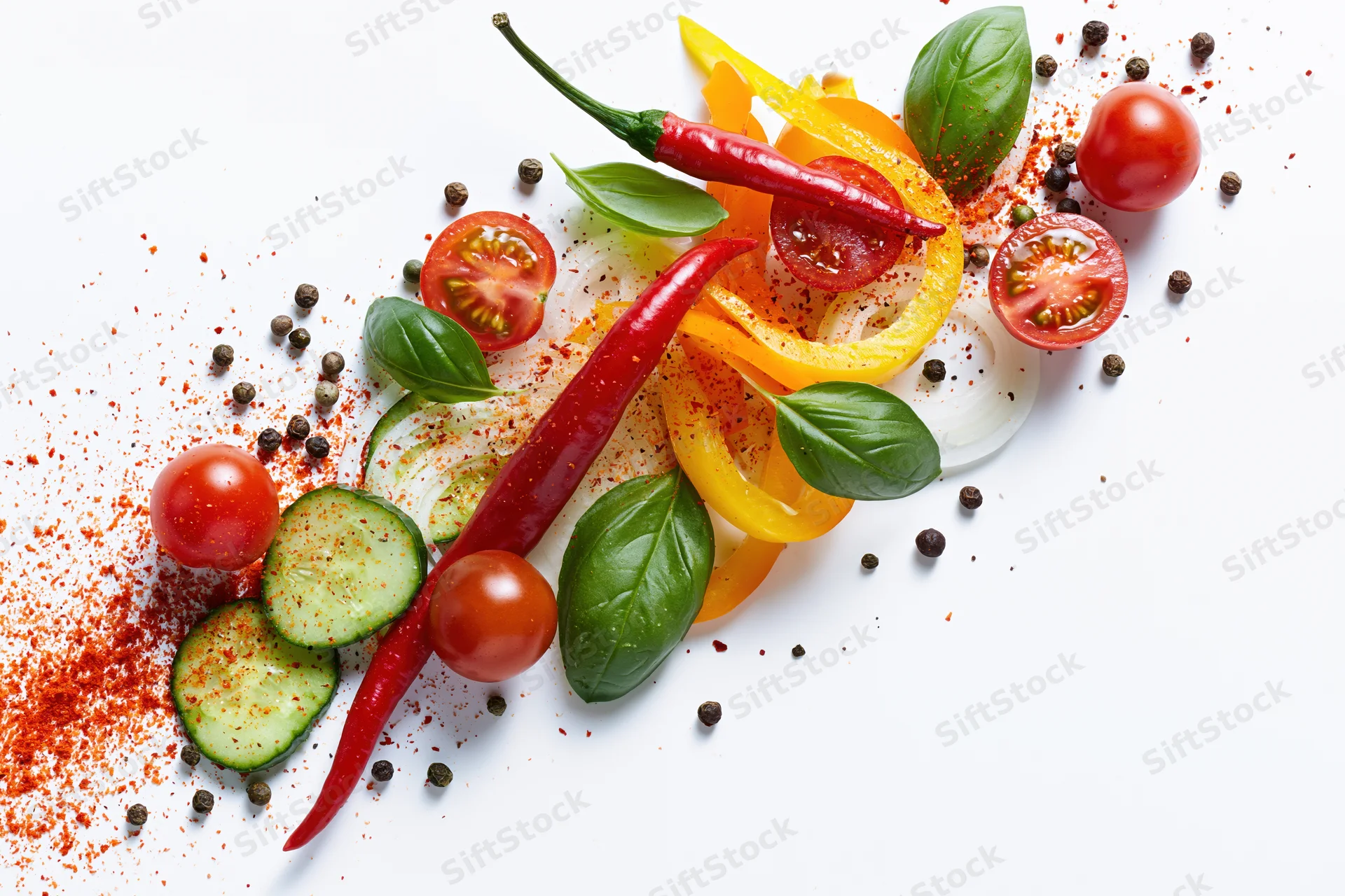Fresh vegetables and herbs arranged in a dynamic flat lay on white background