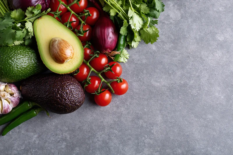 Guacamole ingredients arranged on a gray concrete surface with copyspace