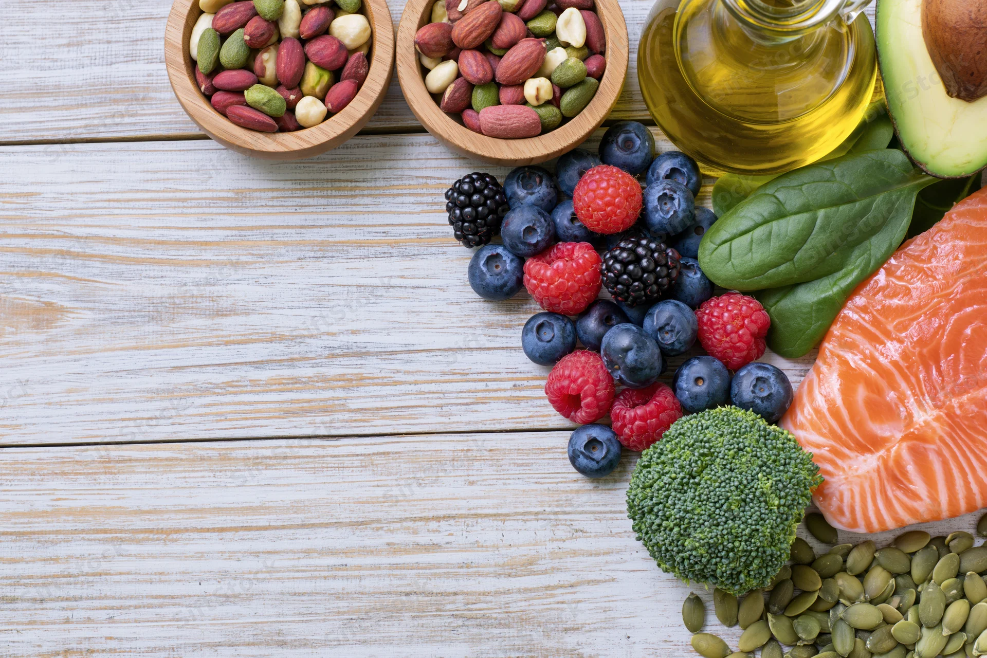 Healthy food ingredients arranged on whitewashed wooden table with copyspace