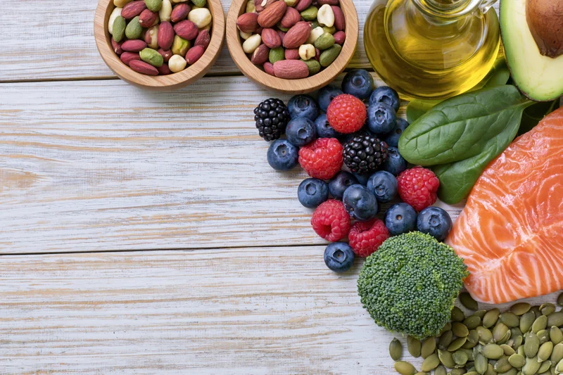 Healthy food ingredients arranged on whitewashed wooden table with copyspace