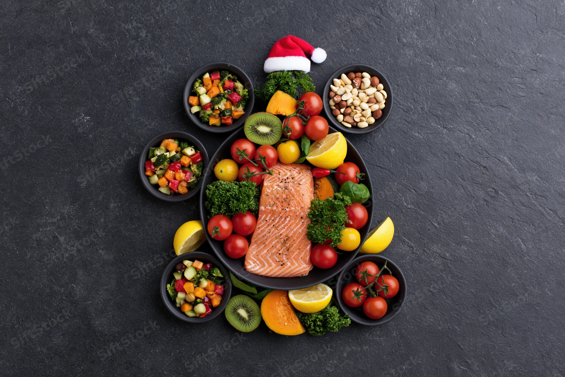 Healthy foods arranged in christmas tree shape on dark slate surface