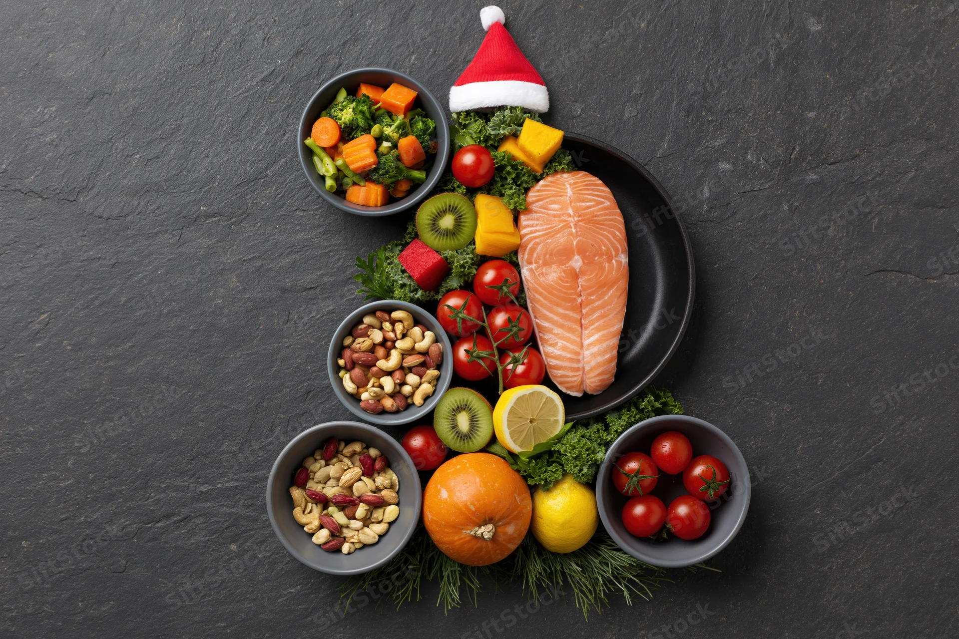 Healthy foods arranged in christmas tree shape on dark slate surface