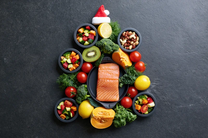Healthy foods arranged in christmas tree shape on dark slate surface