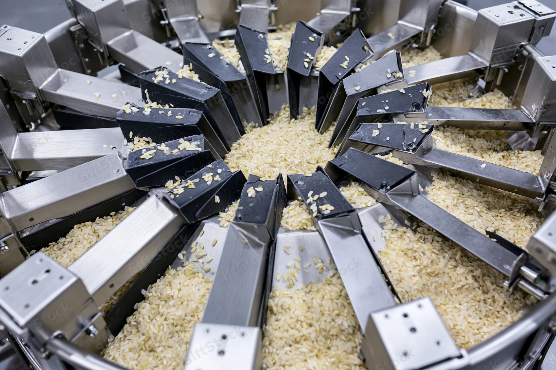 Industrial multihead weigher machine dispensing dry rice grains in a food processing facility