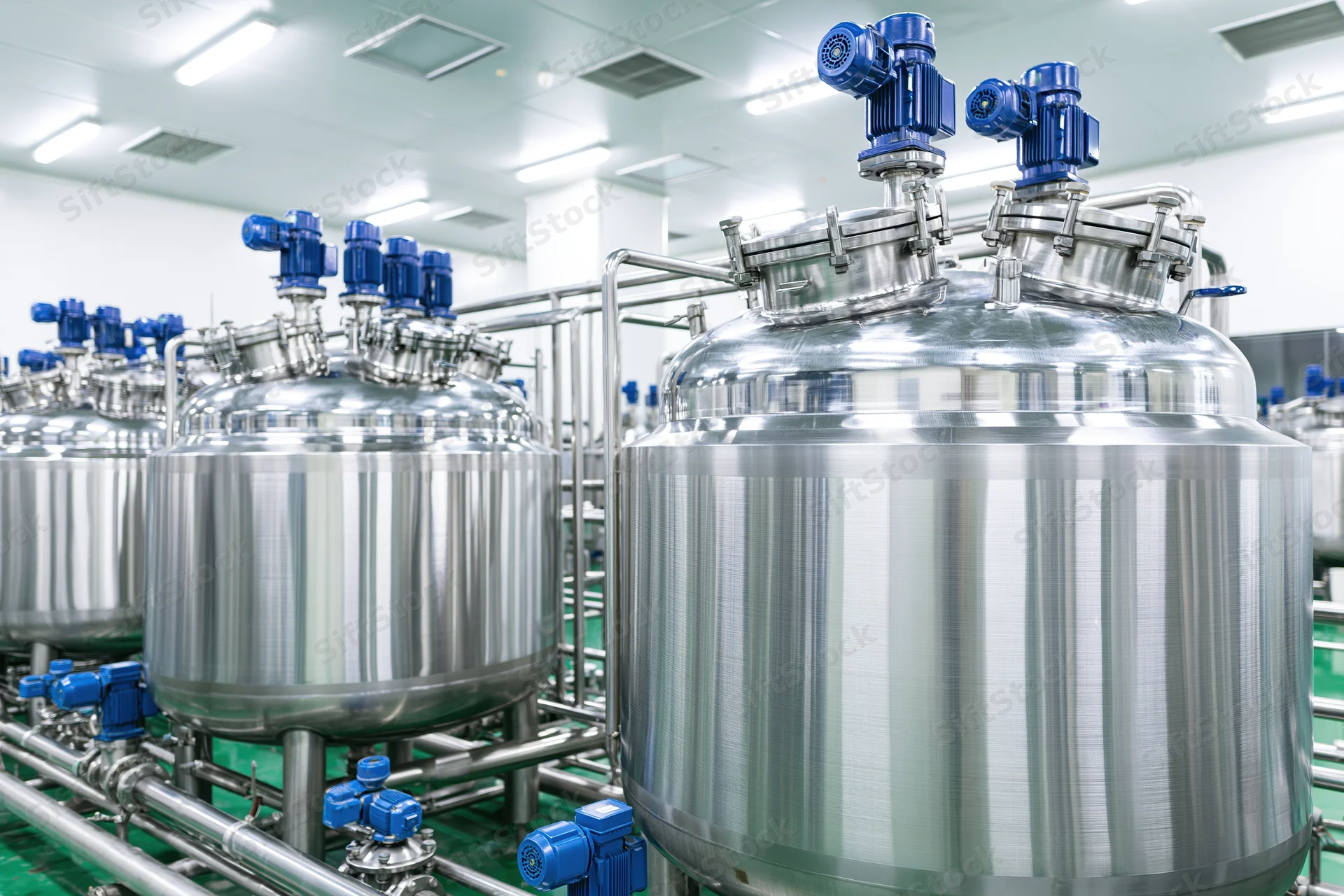 Stainless steel mixing tanks and processing vessels in a clean industrial facility