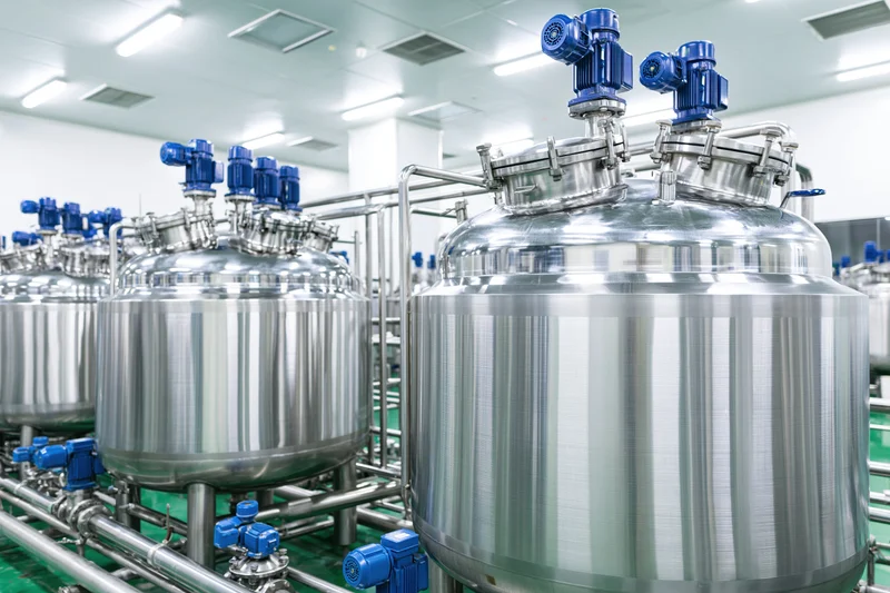 Stainless steel mixing tanks and processing vessels in a clean industrial facility