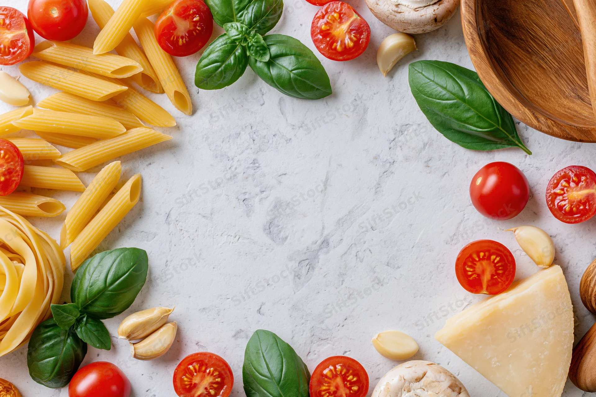 Italian cooking ingredients arranged as a flat lay border on a white marble surface