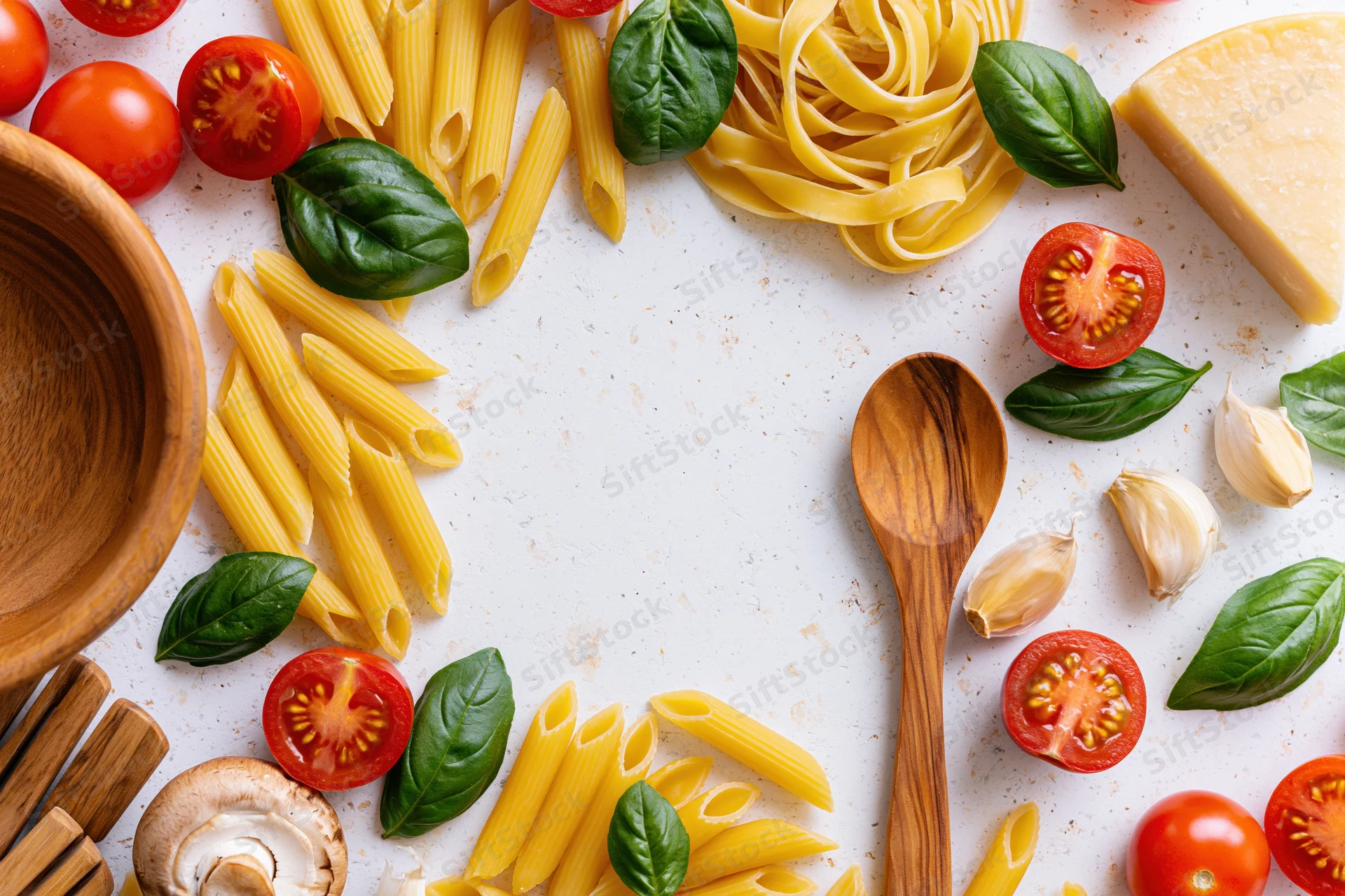Italian cooking ingredients arranged in a flat lay border on a white countertop with copyspace in center