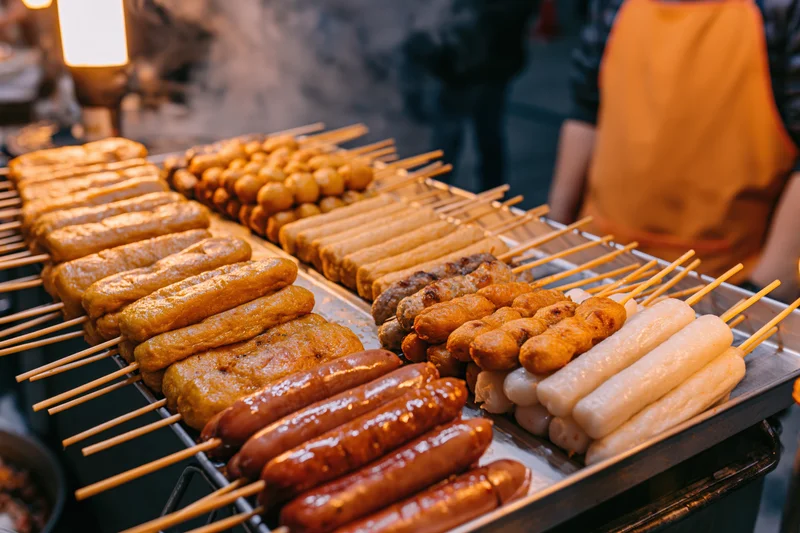 Rows of grilled korean street food skewers on a night market stall
