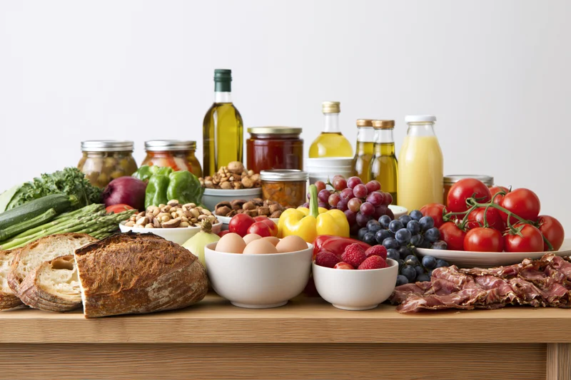Whole foods arranged in a flat-lay spread on a wooden table