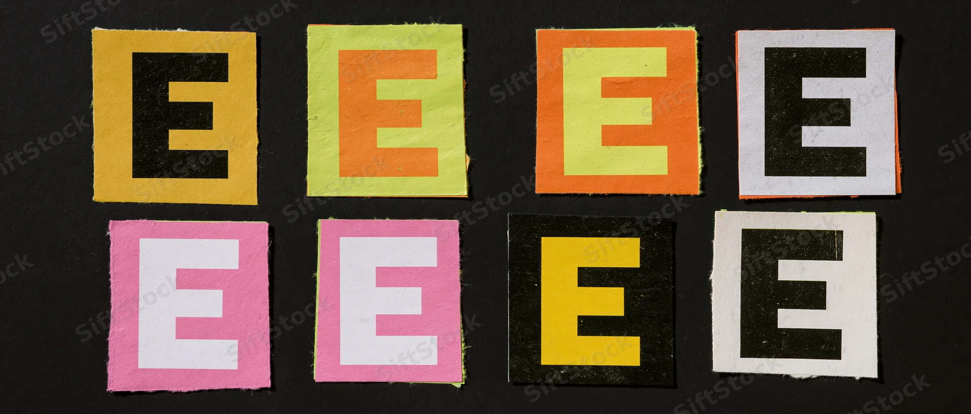 Eight colorful cut-out letter E tiles arranged in two rows on black background
