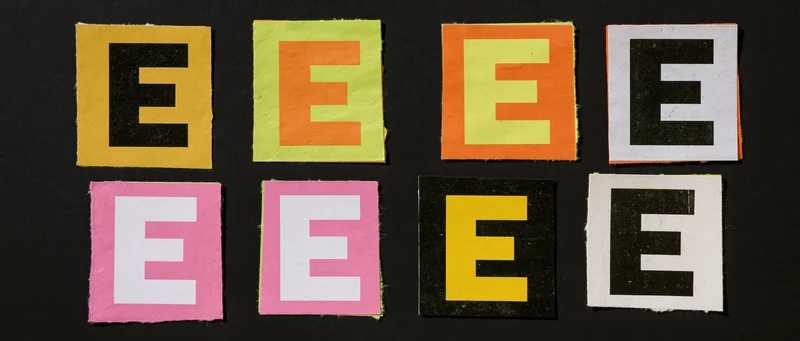 Eight colorful cut-out letter E tiles arranged in two rows on black background