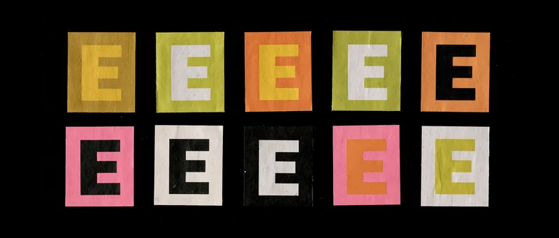 Nine colorful paper cutout letter e tiles arranged in two rows on black background