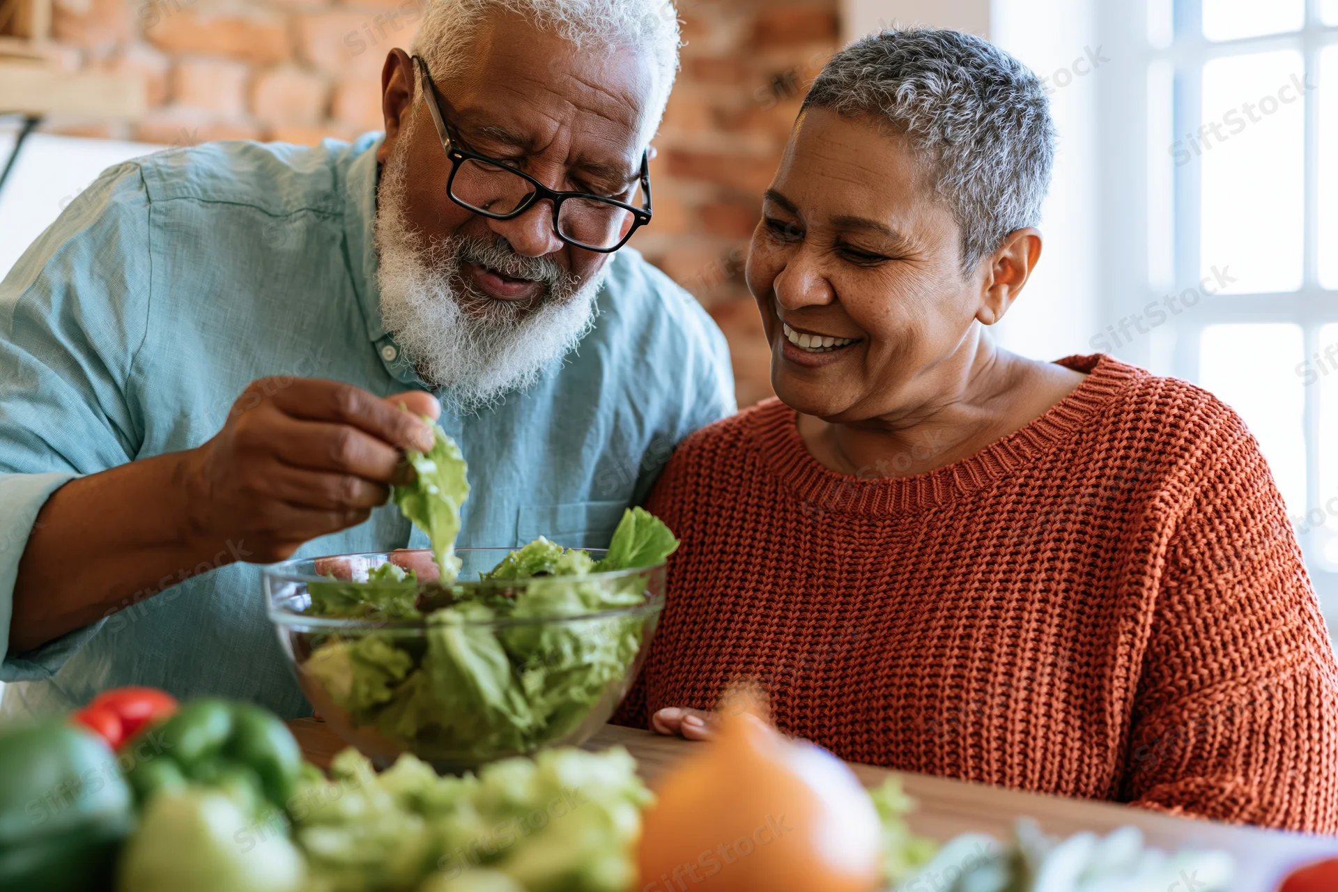 Senior couple preparing salad together at kitchen counter