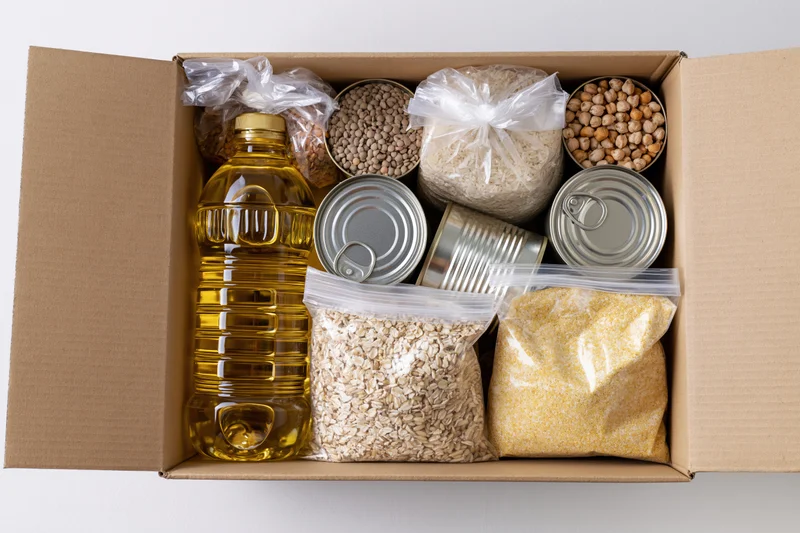Open cardboard box filled with nonperishable food items arranged for donation