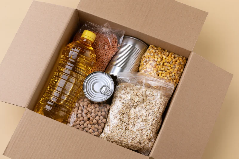 Open cardboard box filled with nonperishable food items for donation