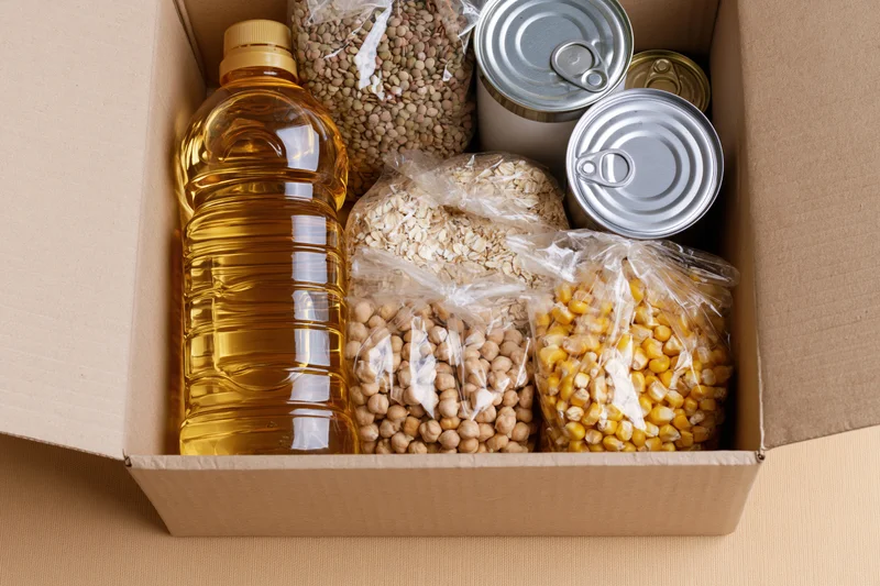 Open cardboard box filled with nonperishable food items for donation