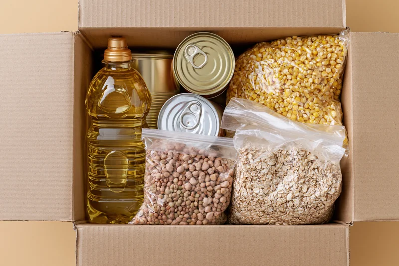 Open cardboard box filled with nonperishable food items for donation