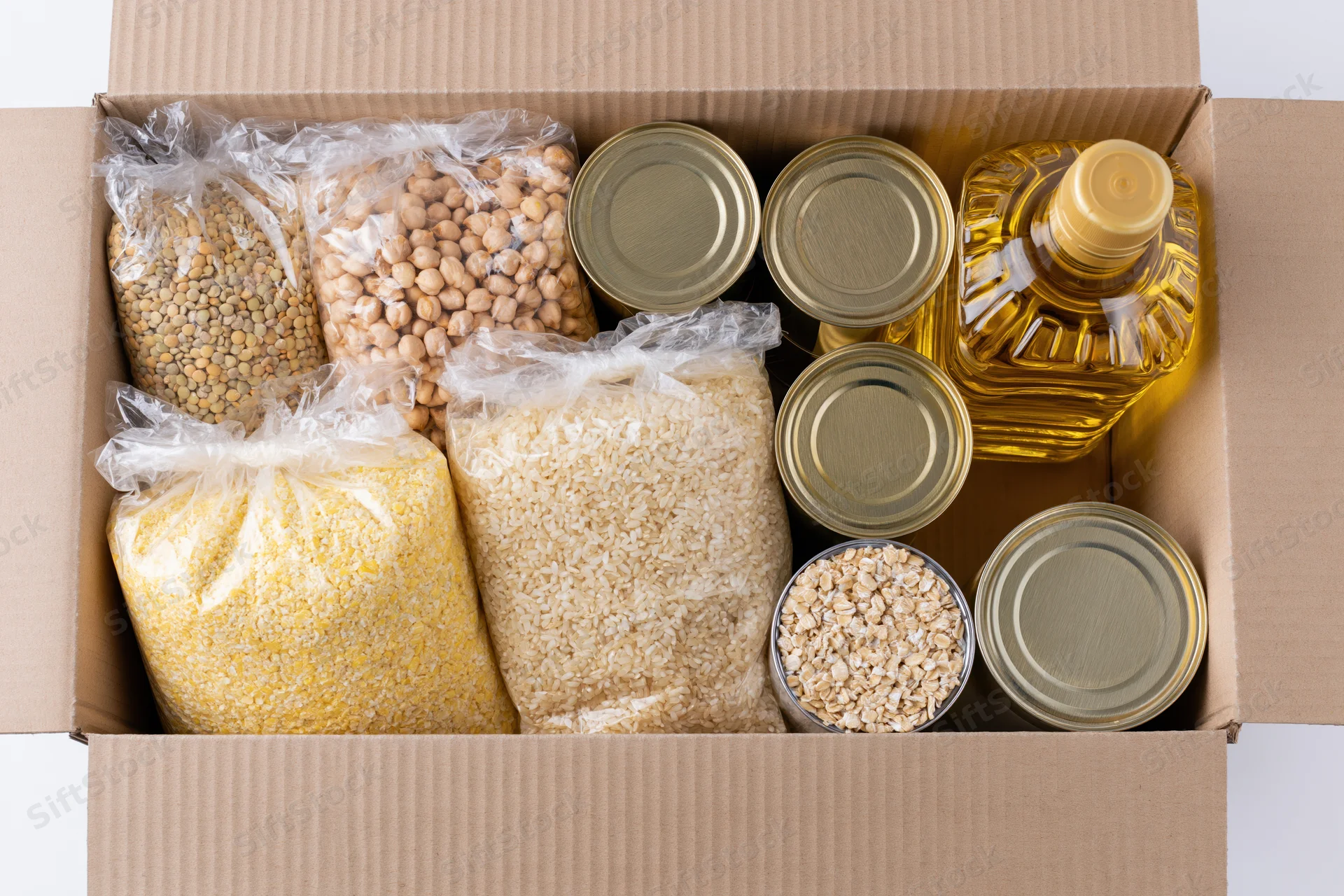 Open cardboard box filled with dry food staples and canned goods for donation