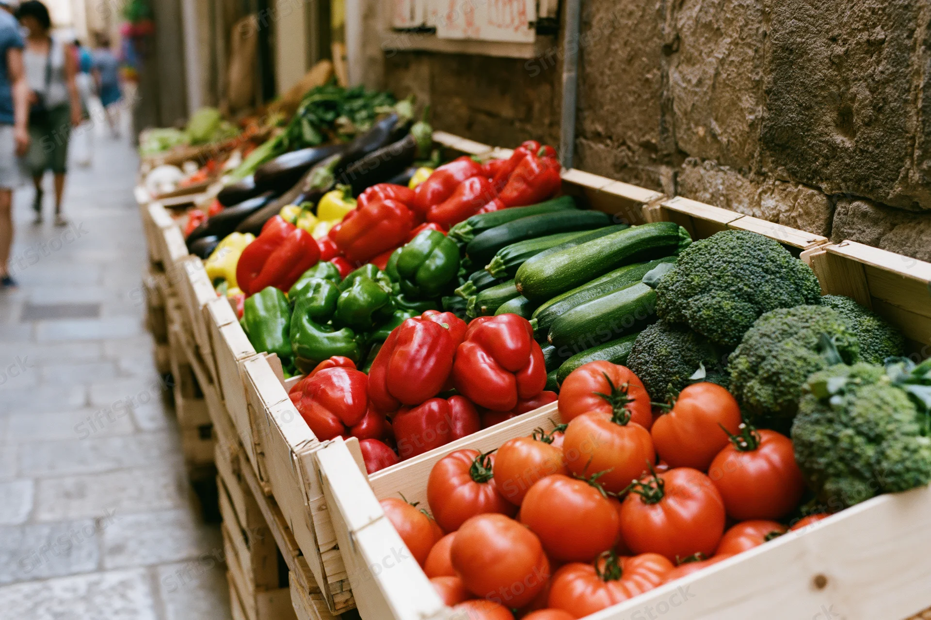 Fresh vegetables arranged in wooden crates at an outdoor italian market stall