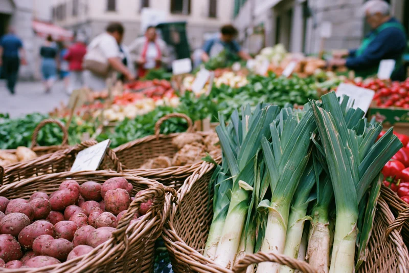 Baskets of fresh vegetables arranged at an outdoor market stall