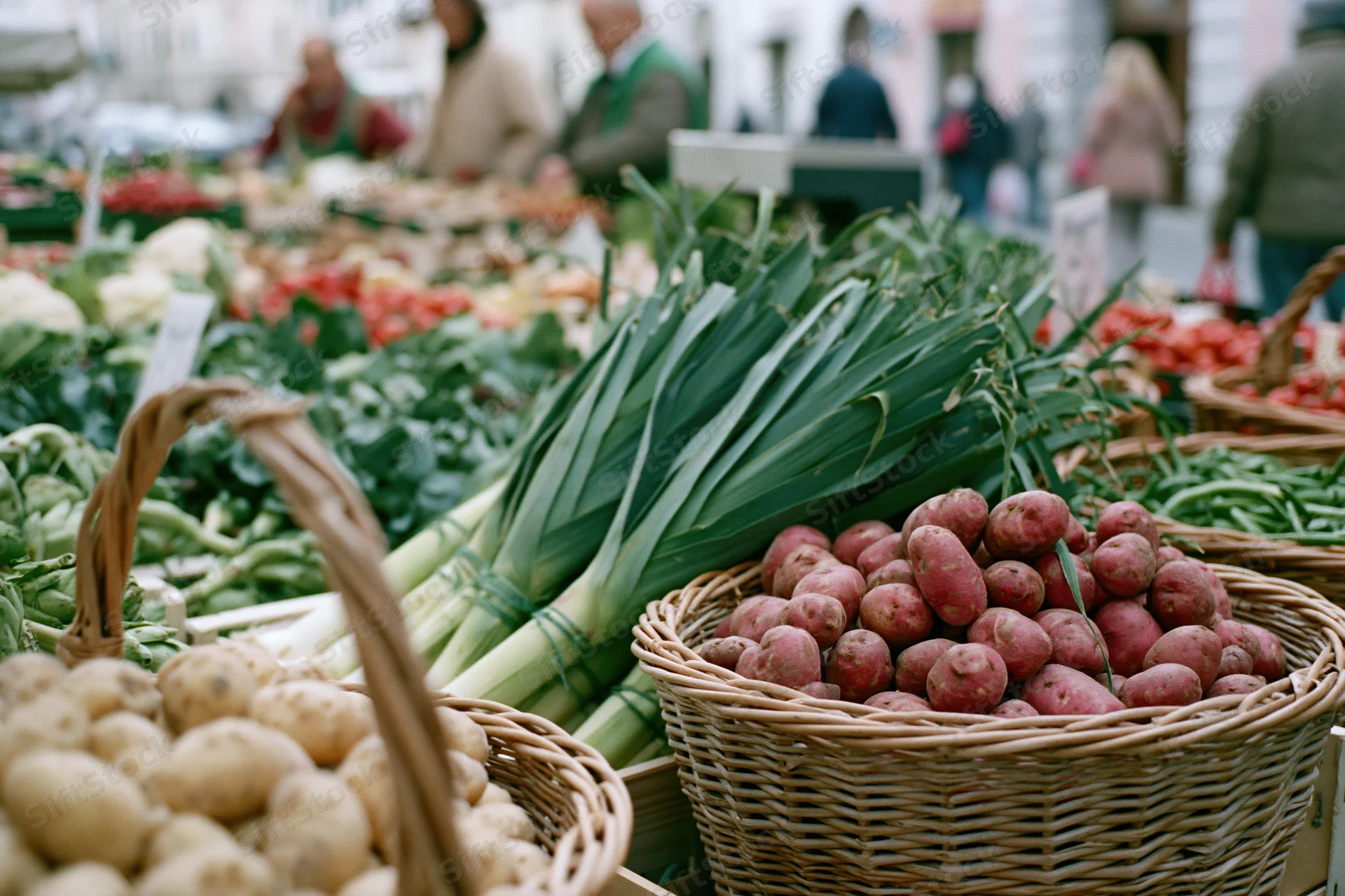 Baskets of fresh vegetables arranged at an outdoor market stall
