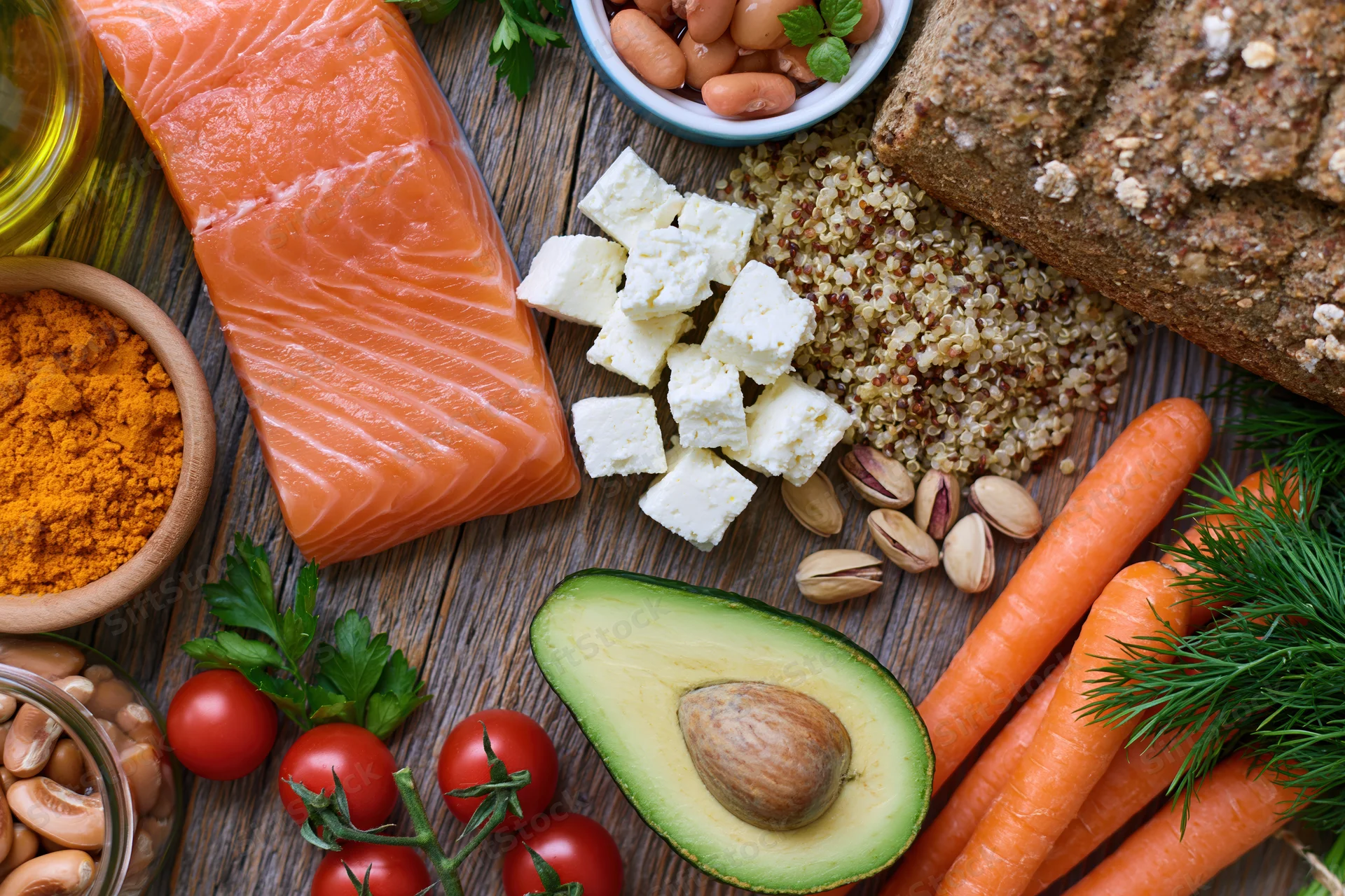Overhead flat-lay of mediterranean diet ingredients arranged on wooden table