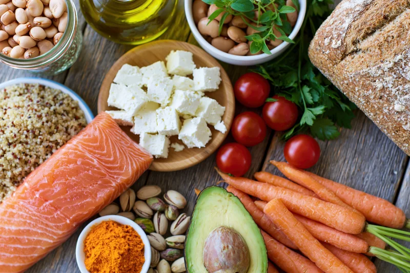 Overhead flat-lay of mediterranean diet ingredients arranged on wooden table