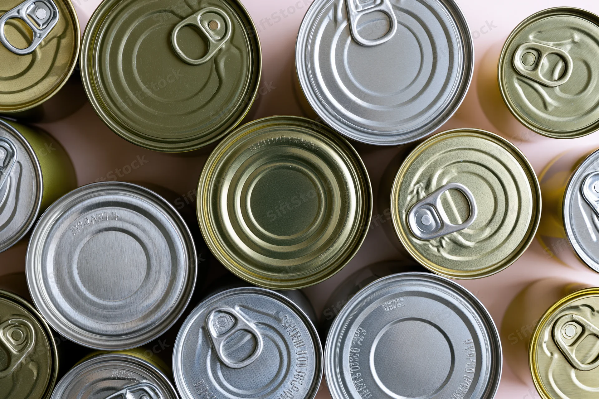 Overhead flat-lay of multiple metal food cans arranged closely on a light surface