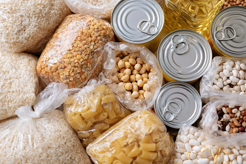 Overhead flat lay of assorted dry pantry staples and canned goods arranged together
