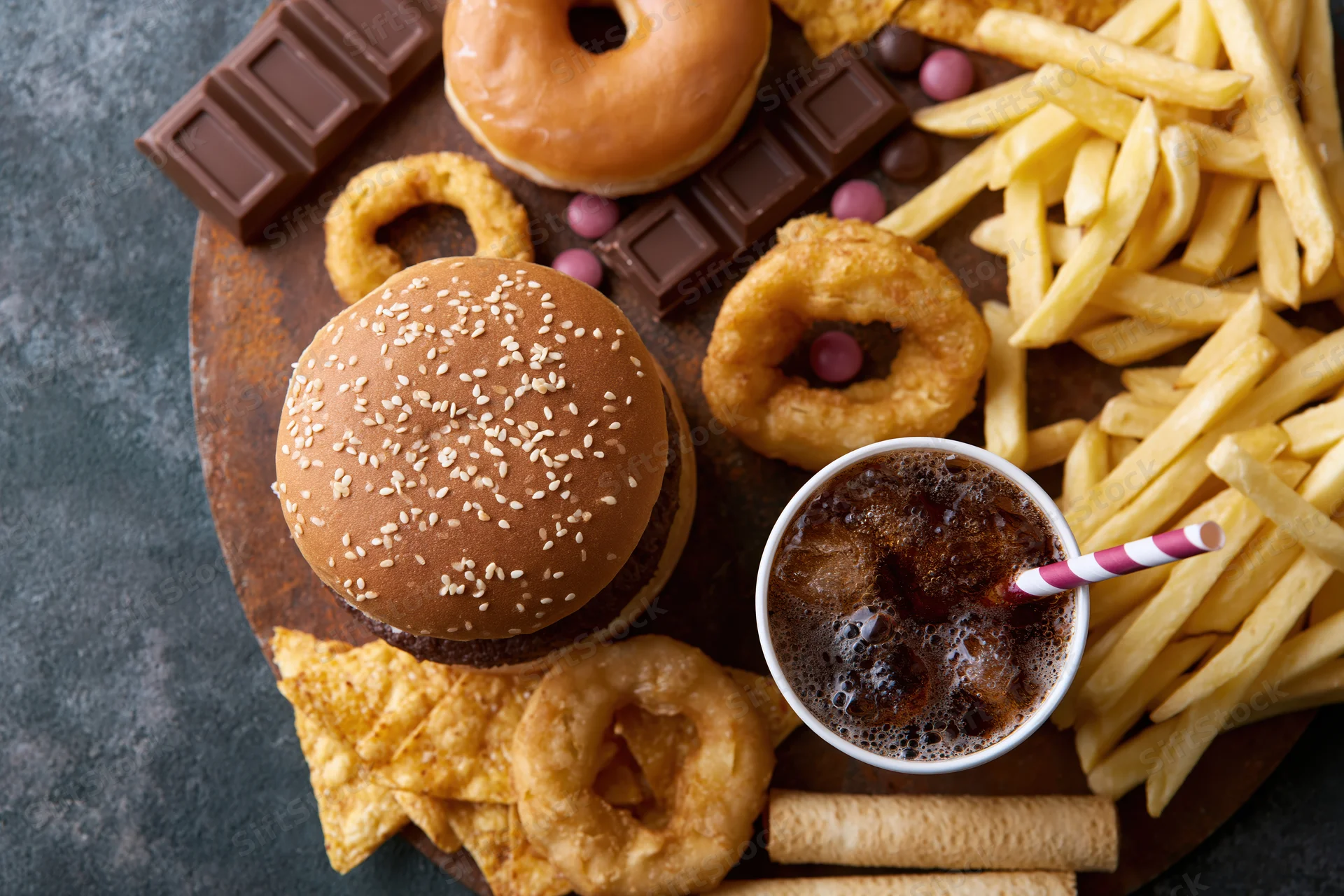 Overhead flat lay of assorted junk food on dark surface