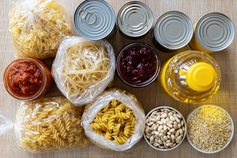 Assorted pantry staples arranged on wooden surface in overhead flat lay