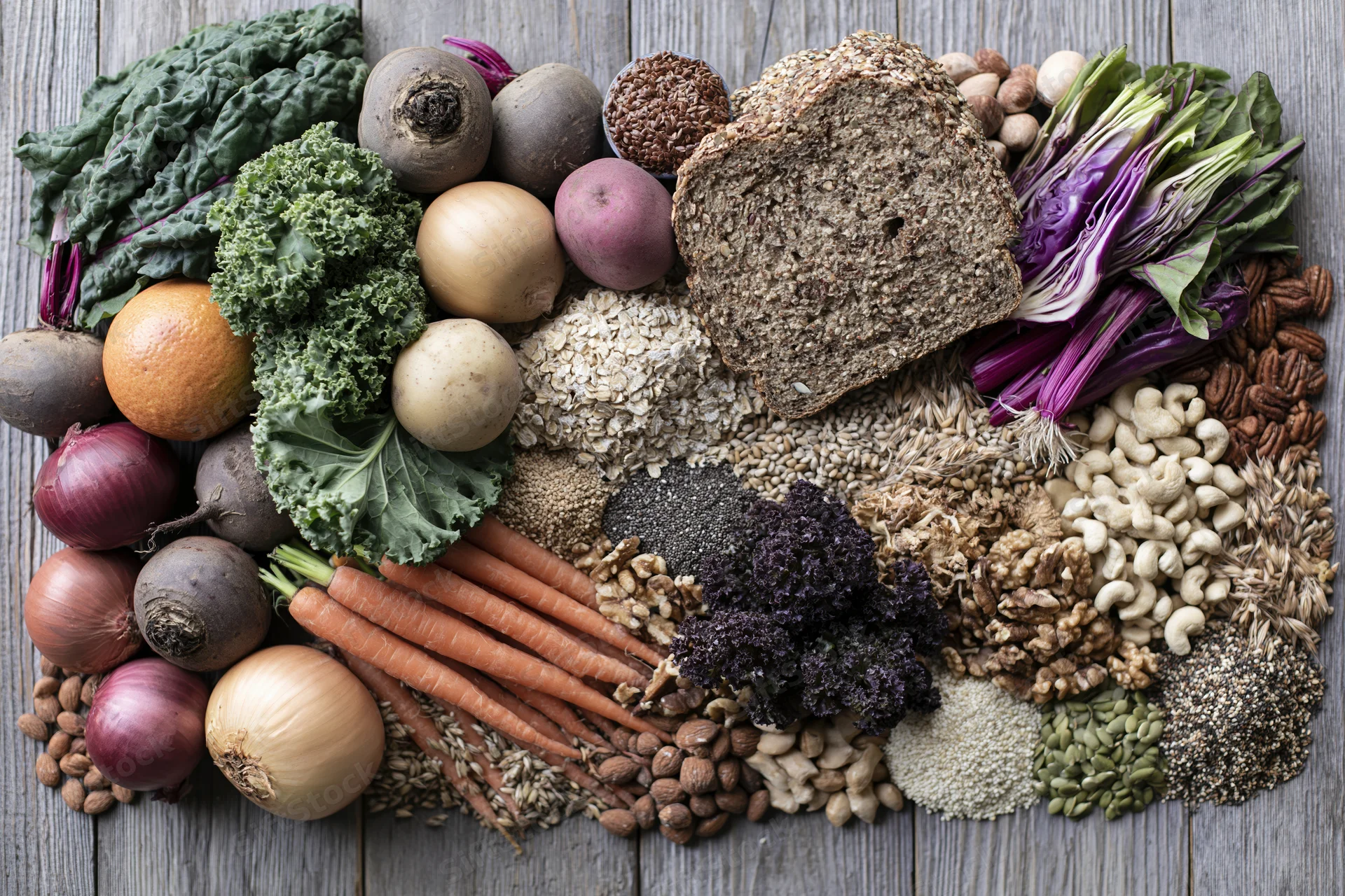 Overhead flat lay of whole foods arranged on wooden surface