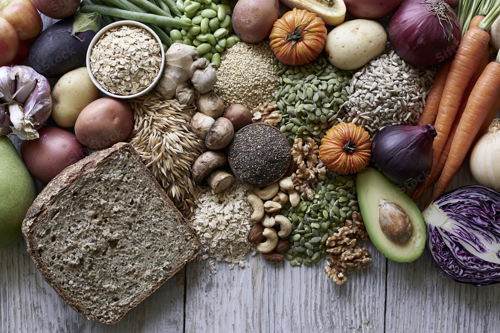 Overhead flat lay of whole foods arranged on wooden surface