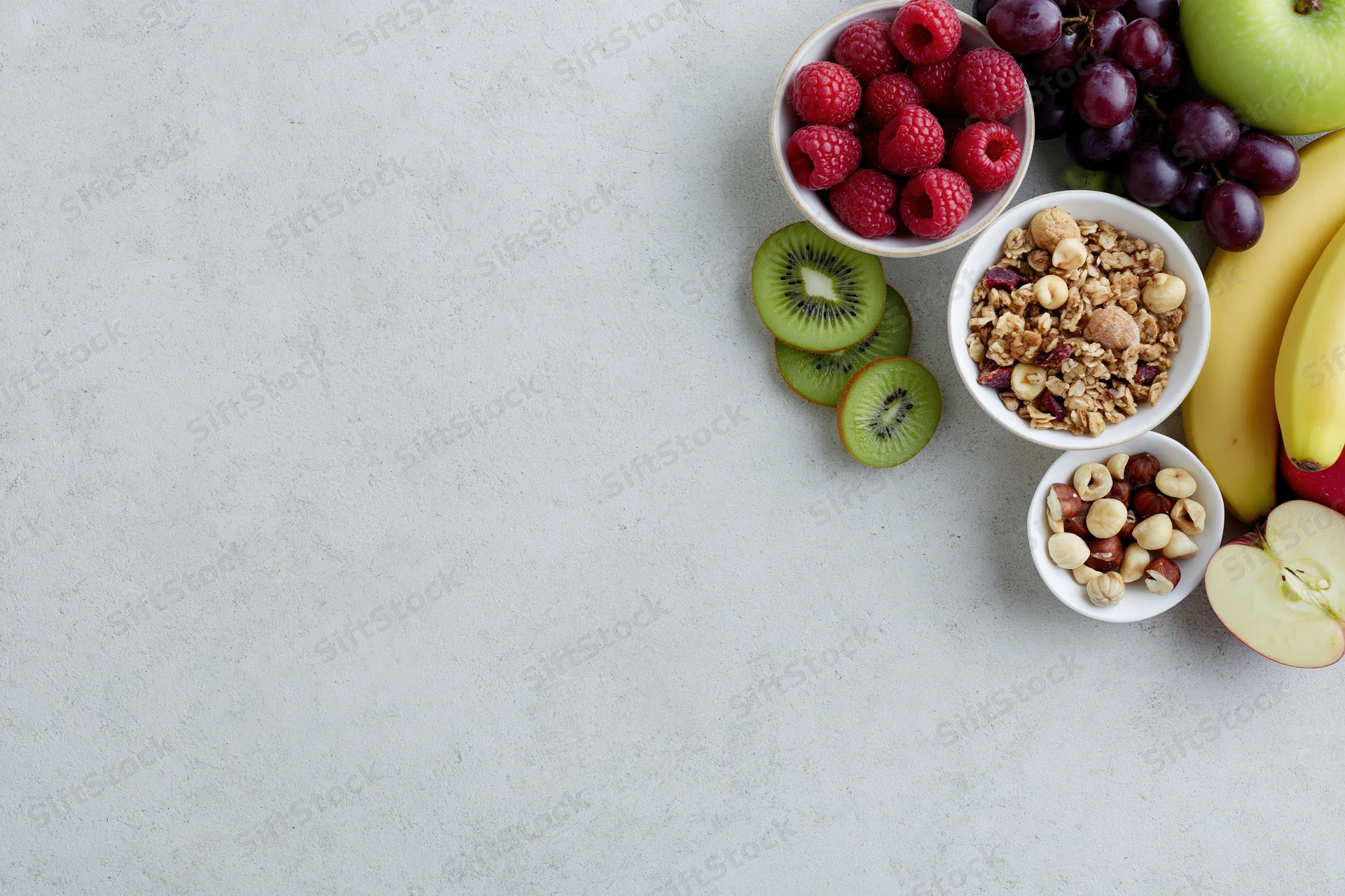 Breakfast ingredients arranged along the right side of a white surface with copyspace on the left