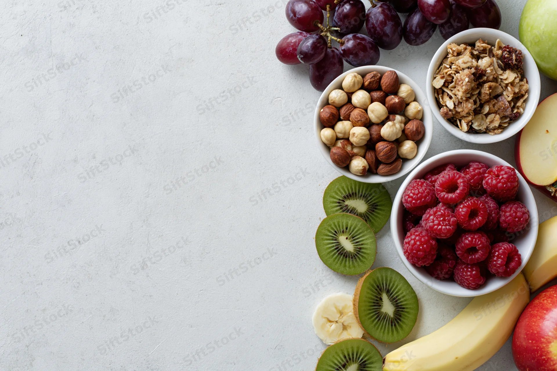 Breakfast ingredients arranged along the right side of a white surface in a flat lay overhead view