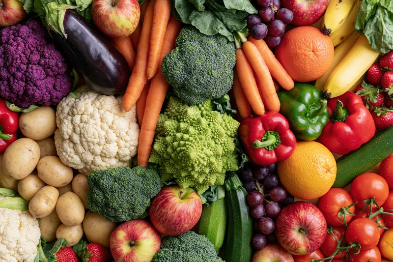 Overhead flat lay of densely packed fresh vegetables and fruits