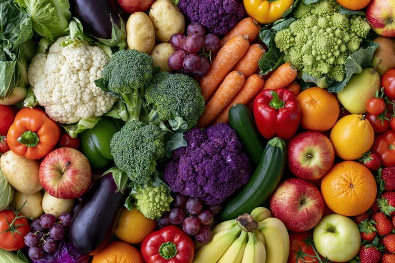 Overhead flat lay of densely packed fresh vegetables and fruits