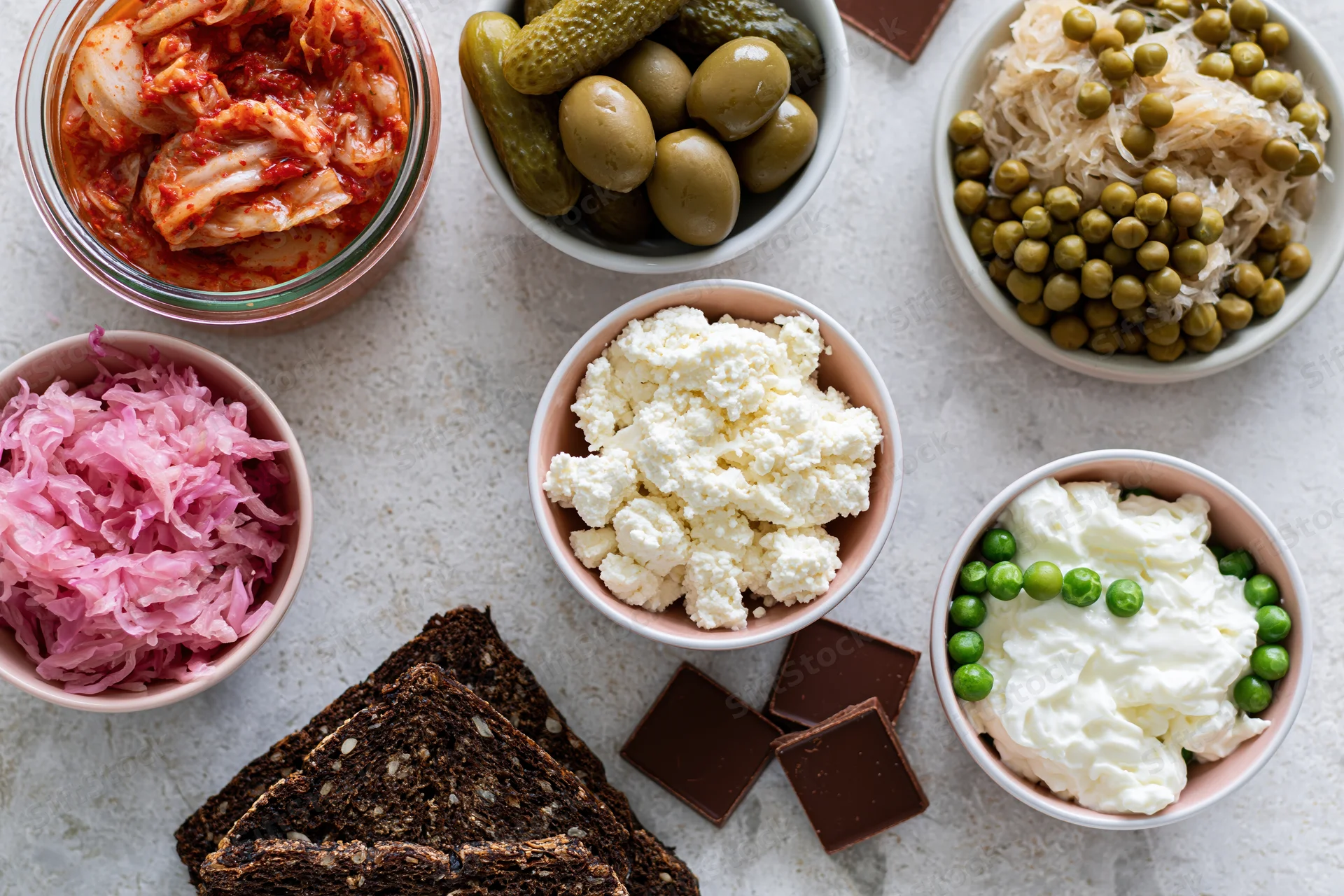 Overhead flat lay of fermented and probiotic foods arranged on a countertop in bowls and on plates
