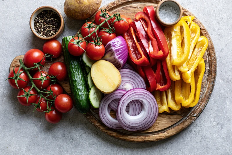 Fresh vegetables arranged on a worn wooden cutting board for meal preparation