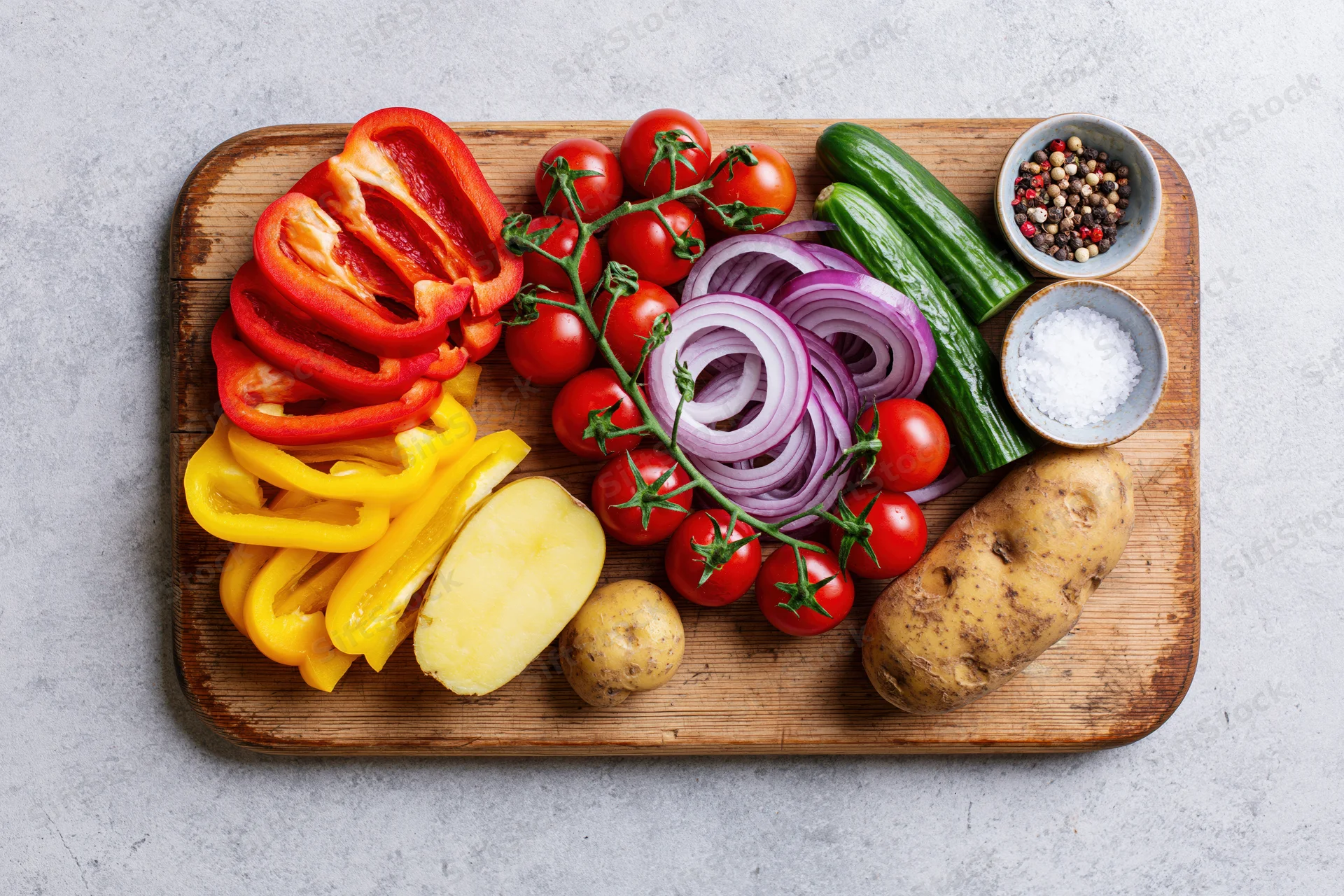 Fresh vegetables arranged on a worn wooden cutting board for meal preparation